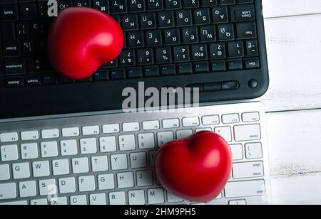 Zwei rote Herzen auf der pc-Tastatur einander gegenüberliegende virtuelle Liebe Stockfoto
