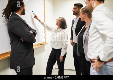 Geschäftsfrau als Sprecherin mit Erfahrung im Strategie-Workshop, der eine Präsentation auf dem Whiteboard gibt Stockfoto