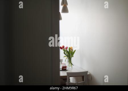 Geburtstagskuchen mit 32-Nummern-Kerze mit einem Blumenstrauß in einer Vase auf dem Hintergrund Stockfoto