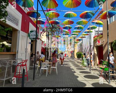 Puerto Plata, DR – 10. Januar 2022: Menschen spielen und geselligen sich auf der Umbrella Street in Puerto Plata, DR. Stockfoto