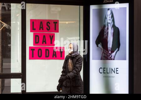 London, Großbritannien. 8. Februar 2022. Ein Einkäufer passiert ein Schild „Last Day Today“ in der Oxford Street. Das British Retail Consortium hat berichtet, dass die Einzelhandelsumsätze im Januar im Vergleich zum 2021. Januar zwar gestiegen sind, die steigende Inflation und die höheren Energiekosten jedoch zwangsläufig dazu führen werden, dass die Käufer ihre Ausgaben in den nächsten Monaten eindämmen, was sich negativ auf die Einzelhandelsbranche auswirken wird. Kredit: Stephen Chung / Alamy Live Nachrichten Stockfoto