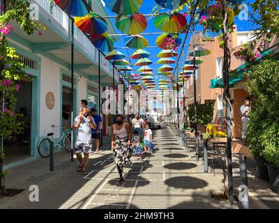 Puerto Plata, DR – 10. Januar 2022: Menschen spielen und geselligen sich auf der Umbrella Street in Puerto Plata, DR. Stockfoto