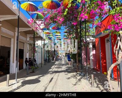 Puerto Plata, DR – 10. Januar 2022: Menschen spielen und geselligen sich auf der Umbrella Street in Puerto Plata, DR. Stockfoto
