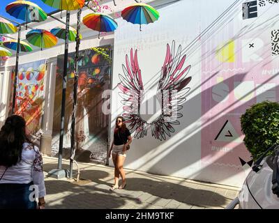 Puerto Plata, DR – 10. Januar 2022: Menschen spielen und geselligen sich auf der Umbrella Street in Puerto Plata, DR. Stockfoto