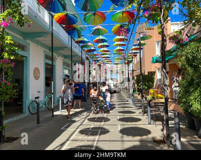 Puerto Plata, DR – 10. Januar 2022: Menschen spielen und geselligen sich auf der Umbrella Street in Puerto Plata, DR. Stockfoto