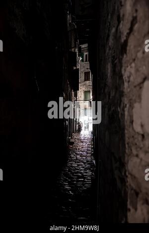 Gruselige Schmale Gasse Mit Licht Am Ende, Alte Häuser Und Kopfsteinpflaster In Der Dunklen Nacht Stockfoto