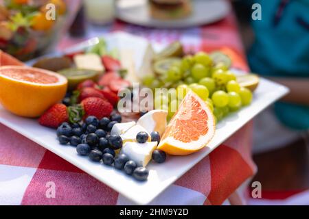 Nahaufnahme selektive Fokussierung verschiedener Früchte mit Käsescheiben in Tablett auf dem Tisch Stockfoto