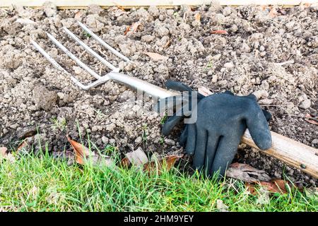 Digging fork in garden with hand gloves Stockfoto