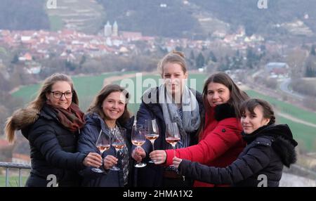 08. Februar 2022, Sachsen-Anhalt, Freyburg: Linda Trarbach (l-r), Deutsche Weinprinzessin, Sina Erdrich, Deutsche Weinkönigin, Luise Böhme, Weinkönigin der Region Saale-Unstrut, Saskia Teucke, Deutsche Weinprinzessin, und Antonia Odenthal, Freyburg Weinprinzessin, Stehen Sie am Unstrut River Valley mit der Stadt Freyburg im Hintergrund. Die Deutschen Weinprinzessinnen und die Deutsche Weinkönigin waren zu Gast im Weinanbaugebiet Sachsen-Anhalt anlässlich ihres ersten Besuches. Während ihrer Amtszeit reisen die Weinbotschafter in alle dreizehn Weinanbauregionen Deutschlands Stockfoto