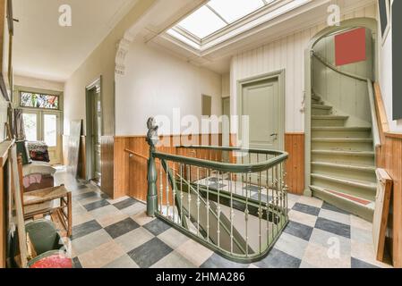 Innenflur mit Treppe und schäbigen Fliesenboden in Retro-Wohnhaus Stockfoto