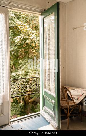 Die Inneneinrichtung des gemütlichen Zimmers mit geöffneten Holzfenstern in einem altmodischen Landhaus Stockfoto