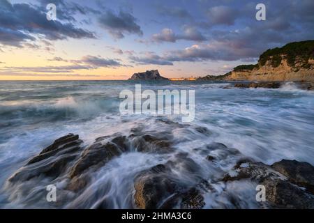 Blick auf die Stadt Calpe bei Sonnenaufgang von Cala Baladrar Stockfoto