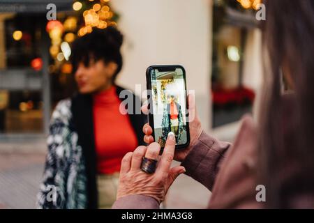 Selektiver Fokus der Ernte unkenntlich Dame Aufnahme von afroamerikanischen Frau auf dem Smartphone auf der Straße Stockfoto