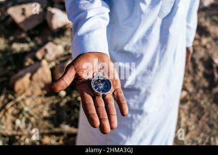 Kurzgeschnittenes, nicht erkennbares männliches Hipster mit Armprothese-Messaging in sozialen Medien über Handy, während es im Sommer auf der Stadtstraße spazierenging Stockfoto