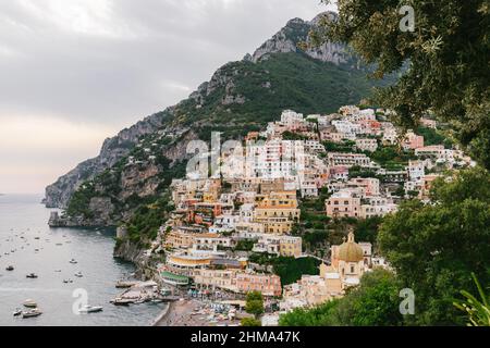 Stadt mit typischen Wohnhäusern am Hang der felsigen Klippe an der Küste mit Strand in der Nähe von ruhigen Meer in Italien Stockfoto