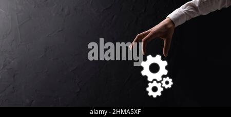 Hand hält Metall Zahnräder und Zahnräder Mechanismus der Interaktion Teamwork Konzept, Hand halten Gruppe von virtuellen Zahnräder Rad. Stockfoto