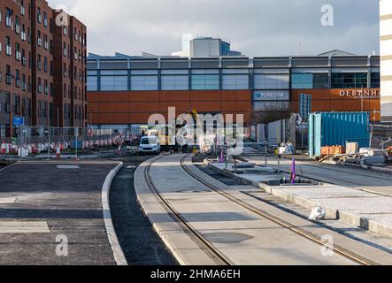 Leith, Edinburgh, Schottland, Großbritannien, 8th. Februar 2022. Straßenbahnen nach Newhaven Bau: Da sich das Großprojekt dem letzten Jahr nähert, die Arbeiten termingerecht und im Frühjahr 2023 im Rahmen des Budgets von £207,3m fertiggestellt werden, sind in Leith zahlreiche Straßen für den Verkehr gesperrt. Mehr als 60 % der Gleise wurden nun verlegt (2,8km) und 85 % der Umleitungen der Versorgungsunternehmen wurden durchgeführt. Im Bild: Die Straßenbahnschienen auf dem Ocean Drive neben dem Ocean Terminal Einkaufszentrum Stockfoto