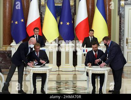 KIEW, UKRAINE - 8. FEBRUAR 2022 - Vorsitzender des Vorstands der Ukrainischen Eisenbahn Oleksandr Kamyshin (2nd R, Front) und Vorsitzender des Verwaltungsrats und CEO von Alstom Henri Poupart-Lafarge (2nd L, Front) unterzeichnung einer Absichtserklärung zwischen der JSC Ukrzaliznyzsia und Alstom Transport SA in Anwesenheit des Präsidenten der Französischen Republik Emmanuel Macron und des Präsidenten der Ukraine Wolodymyr Zelenskyy (L bis R, zurück) im Mariinskyi-Palast, Kiew, der Hauptstadt der Ukraine. Stockfoto