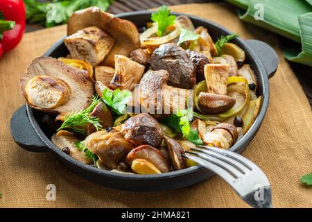 Gekochte Steinpilze in der Pfanne auf dem Holztisch. Stockfoto