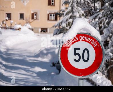 Cinuos-Chel, Schweiz - 3. Februar 2022: Schneebedecktes Straßenschild für Geschwindigkeitsbegrenzung auf 50 km in romanischer Sprache im schweizer Dorf Cinuos-CH Stockfoto