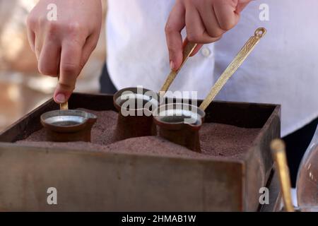 Die Installation von Kaffeekannen im Sand Stockfoto
