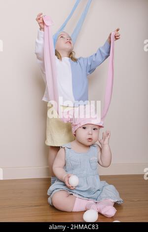 Zwei Schwestern spielen osterhasen Stockfoto