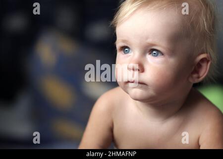 Das nachdenkliche lustige Baby posiert zu Hause Stockfoto
