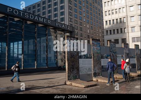 05.02.2022, Berlin, Deutschland, Europa - Touristen schauen sich Originalteile der ehemaligen Berliner Mauer an, die mit Kaugummi bedeckt sind. Stockfoto