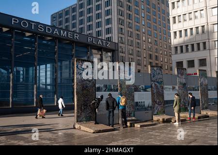 05.02.2022, Berlin, Deutschland, Europa - Touristen schauen sich Originalteile der ehemaligen Berliner Mauer an, die mit Kaugummi bedeckt sind. Stockfoto