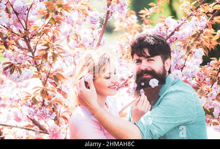 Frühlingsporträt des schönen glücklichen Paares. Das Paar verbringt seine Zeit im blühenden Baumgarten des Frühlings. Osterpaar, Stockfoto