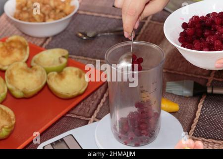 Gefrorene Preiselbeeren wiegen, um Gelee zu machen. Nahaufnahme. Stockfoto