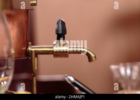 Vintage Kupfer Wasserhahn und verschwommener Hintergrund. Wasserhahn auf einer Kaffeekannen oder Teekannen in der alten Art Nahaufnahme. Stockfoto