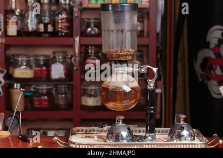 Kräutertee mit einem Vakuumsiphon zubereiten. Nahaufnahme. Stockfoto