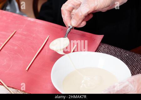 Der Prozess der Herstellung von Pralinen auf Stöcken. Master Class. Nahaufnahme. Stockfoto