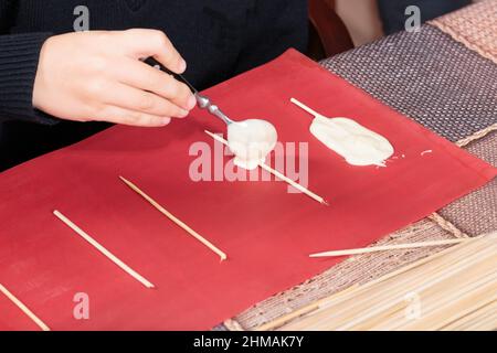 Der Prozess der Herstellung von Pralinen auf Stöcken. Master Class. Nahaufnahme. Stockfoto