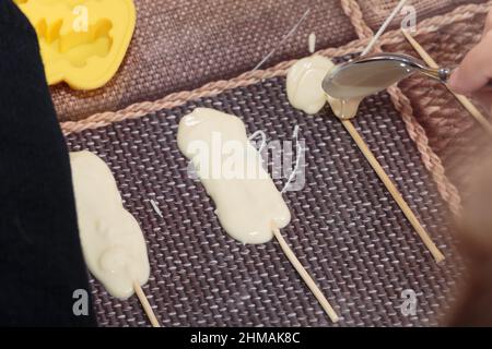 Der Prozess der Herstellung von Pralinen auf Stöcken. Master Class. Nahaufnahme. Stockfoto