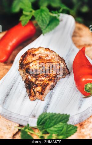 Auswahl an mittelseltenen Steaks, geschnitten mit Messer mit Kartoffelkeilen als Beilage. Kochen im Freien, und tolle Schnitte von Sirloin, Filet. Grill Stockfoto