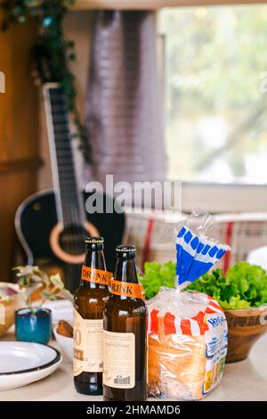 Familie, die im Wohnmobil unterwegs ist. Im Inneren Haus auf Rädern, Anhänger, Wohnwagen. Esstisch. Essen, Gitarre. Romantische Reise, Freiheit Leben.Campingplatz über Nacht, Stockfoto