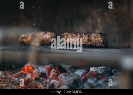 Auswahl an mittelseltenen Steaks, geschnitten mit Messer mit Kartoffelkeilen als Beilage. Kochen im Freien, und tolle Schnitte von Sirloin, Filet. Grill Stockfoto