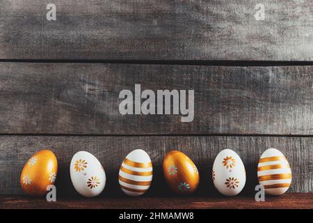 Ostern Urlaub konzeptionellen Hintergrund auf rustikalen Holzbrettern. Draufsicht von oben auf verschiedene Ostereier flach legen. Karte mit Platz zum Platzieren von Text. Minimalkonzept. Hochwertige Fotos Stockfoto