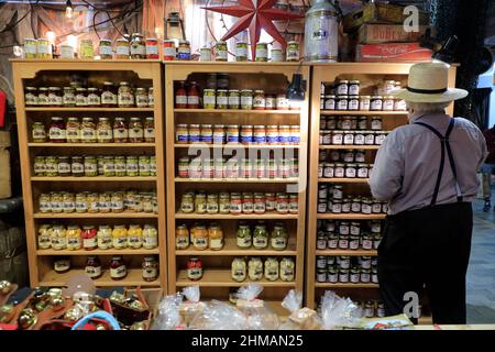 Ein Amish-Verkäufer betreut sein Geschäft am Reading Terminal Market, Philadelphia, Pennsylvania, USA Stockfoto