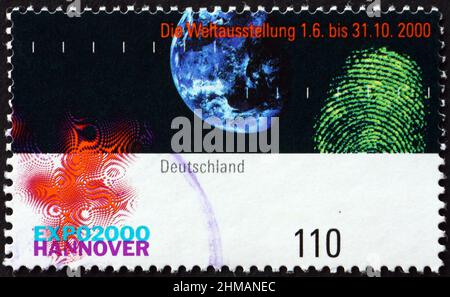 DEUTSCHLAND - UM 2000: Eine in Deutschland gedruckte Marke zeigt das EXPO 2000-Emblem, Erde und Fingerabdruck, um 2000 Stockfoto