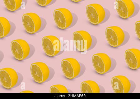 Kreatives Sommermuster mit gelber Zitronenscheibe auf hellrosa Hintergrund. Minimales Sommerkonzept. Stockfoto