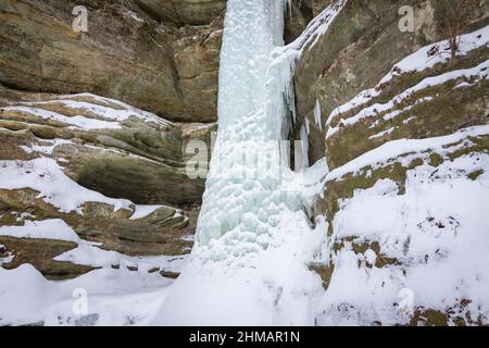 Der gefrorene Wasserfall im Wildcat Canyon an einem lebhaften Wintermorgen. Starved Rock State Park, Illinois, USA. Stockfoto