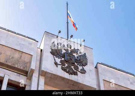 Das russische Wappen und die Staatsflagge auf dem Verwaltungsgebäude Stockfoto