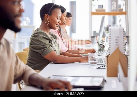Waren immer gerne hilfsbereit. Aufnahme einer Geschäftsfrau, die ein Headset trägt, während sie in einem Callcenter arbeitet. Stockfoto