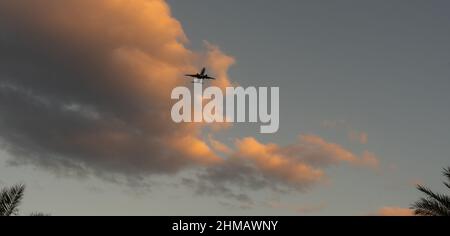 Flugzeug, das bei Sonnenuntergang über dem tropischen Meer fliegt Stockfoto