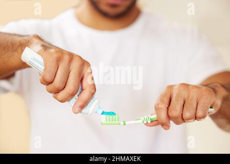 Die richtige Zahnpasta macht den Unterschied. Kurzer Schuss eines Mannes, der Zahnpasta auf seine Zahnbürste legte. Stockfoto