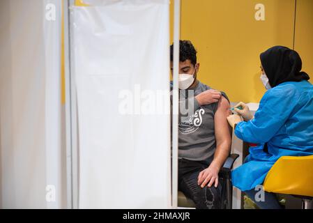 Teheran, Iran. 05th. Februar 2022. Ein junger Mann aus Iran, der eine schützende Gesichtsmaske trägt, erhält eine Dosis des chinesischen Impfstoffes Sinopharm New Coronavirus Disease (COVID-19) im Einkaufszentrum Iranmall im Nordwesten von Teheran. (Foto: Sobhan Farajvan/Pacific Press/Sipa USA) Quelle: SIPA USA/Alamy Live News Stockfoto