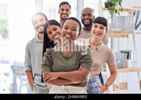 Hinter jedem erfolgreichen Leader steht ein engagiertes Team. Aufnahme einer Gruppe von Geschäftsleuten, die in einem Büro zusammenstehen. Stockfoto